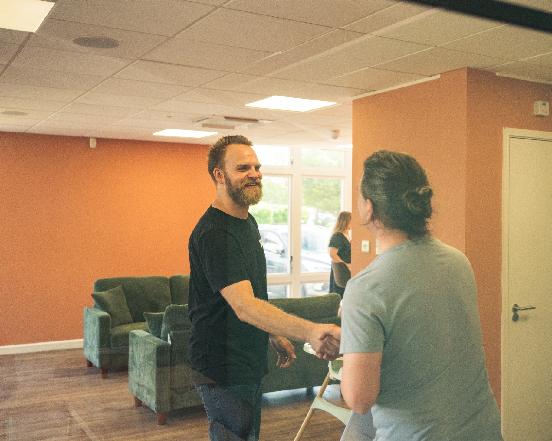 Welcome — handshake at the door